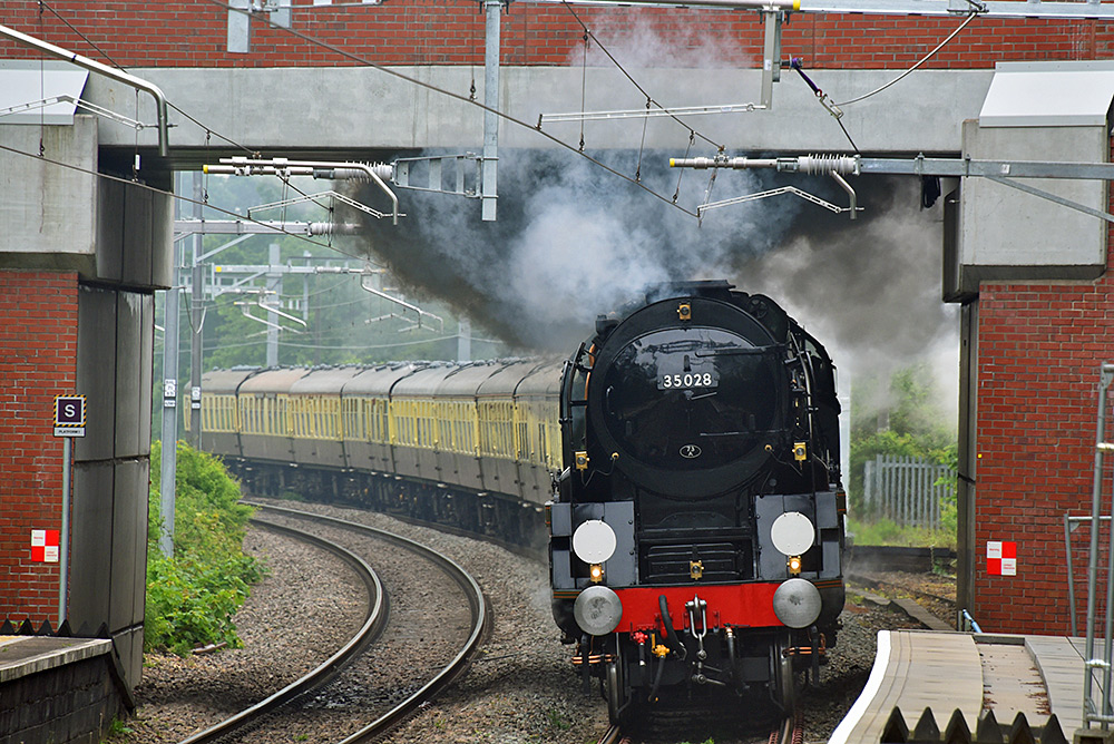 Picture of a steam train passing under a road bridge
