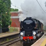 Picture of a steam train passing a station platform