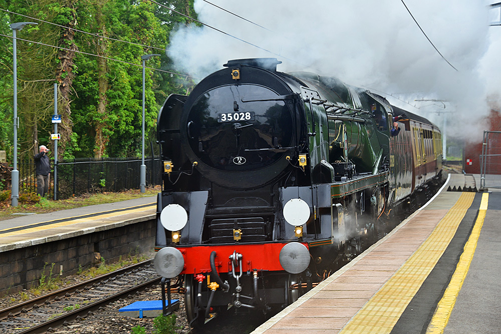 Picture of a steam train passing at a small train station