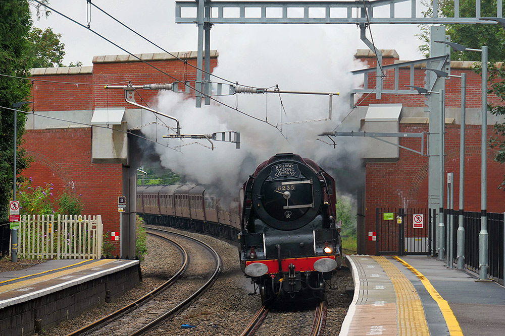 Picture of a steam train passing under a road bridge