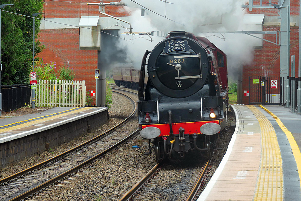 Picture of a steam train passing a rural train station