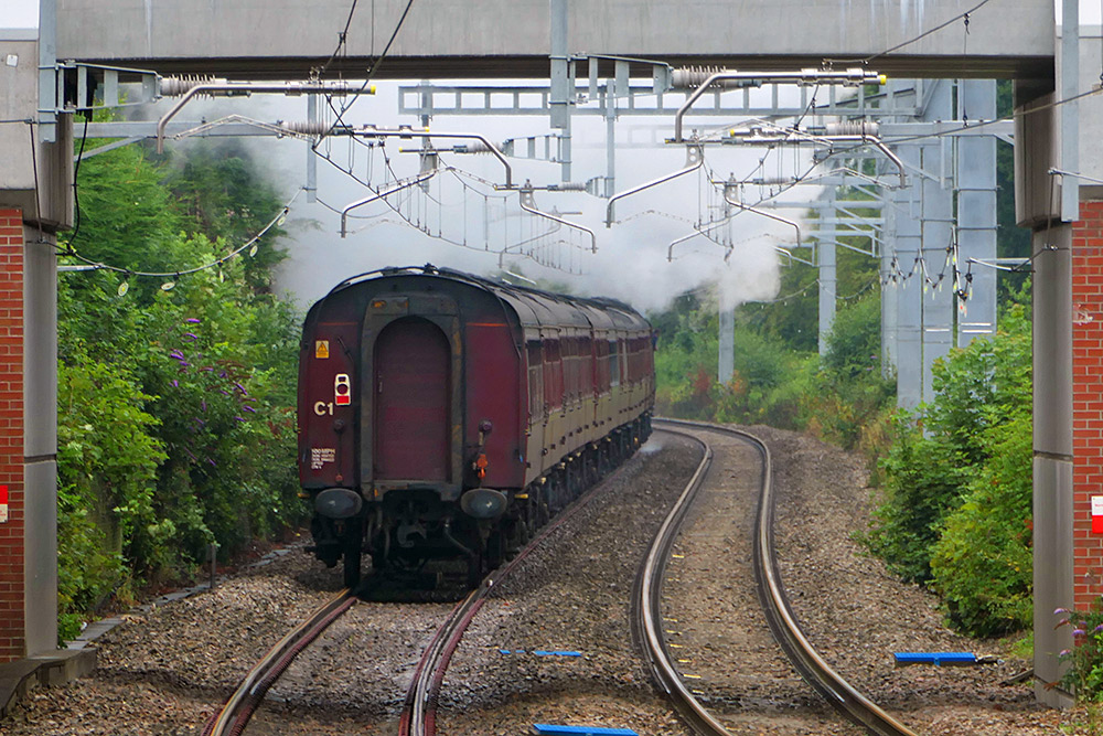 Picture of a steam train from behind, steaming away into the distance