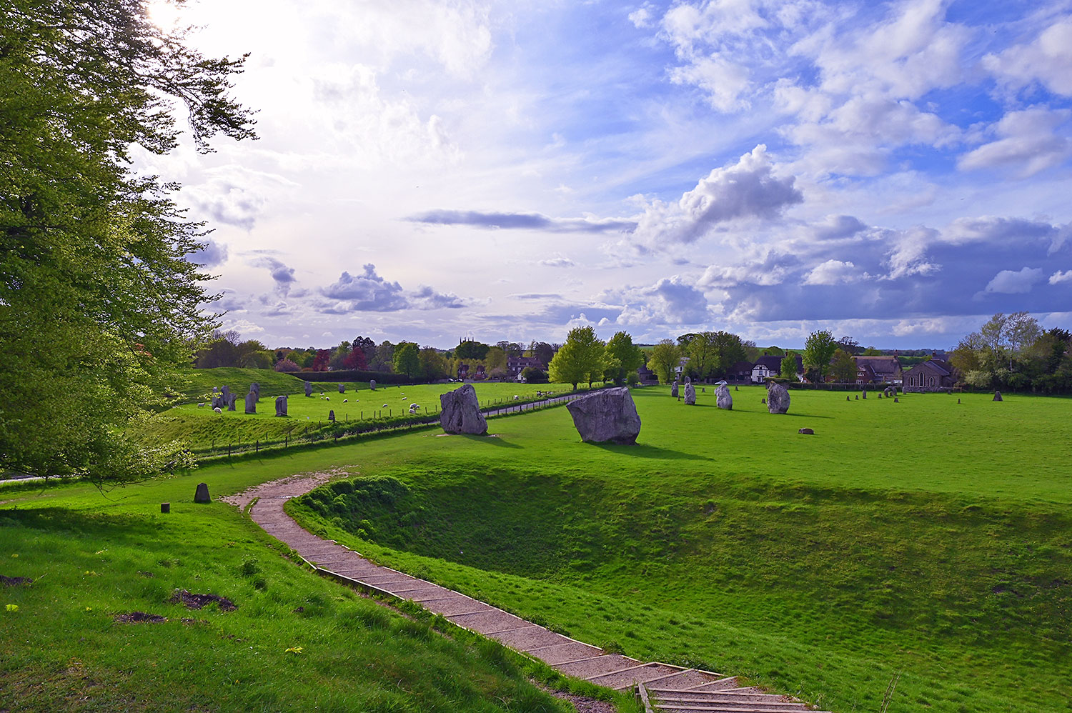 Picture of a stone circle seen from an embankment on a May evening with sunny intervals